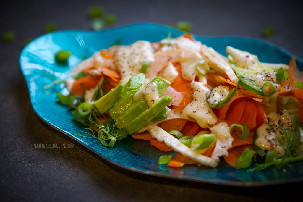 Ginger tahini dressing drizzled over the carrot avocado salad.