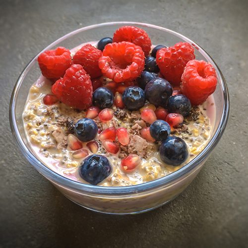 Layered overnight oatmeal with chia, topped with berries.