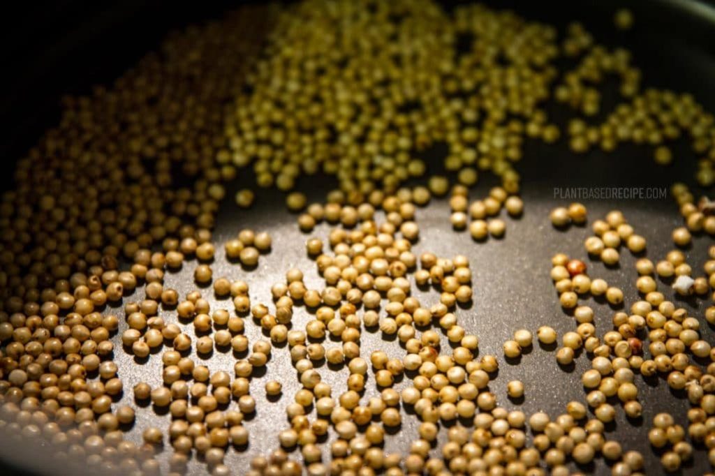 sorghum grain in a pan ready to start popping