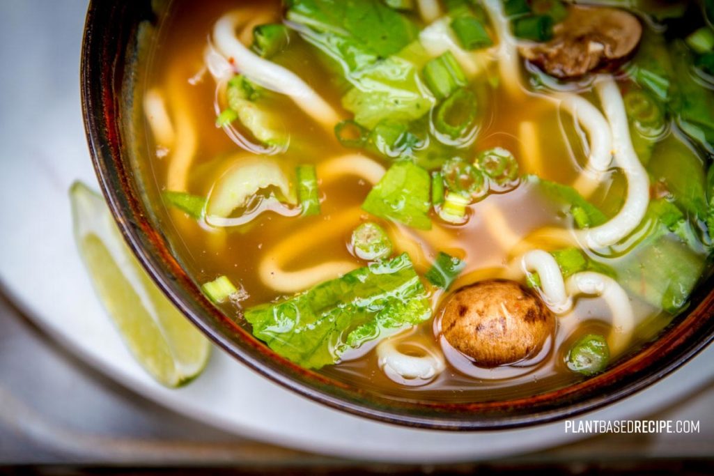 Spicy vegan udon noodle soup with vegetables.