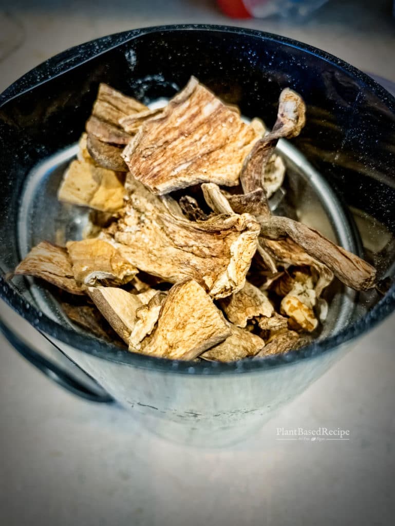 Dried mushrooms being ground to a powder using a coffee grinder