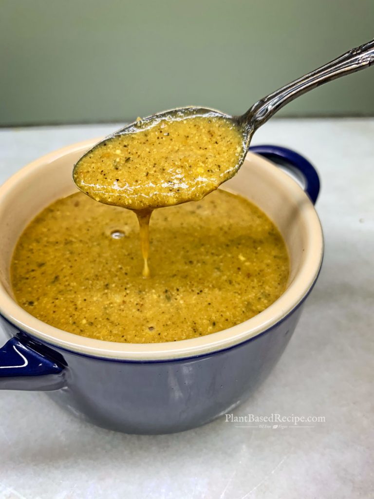 vegan simple miso gravy recipe - spooning gravy from a bowl