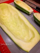 Zucchini boats prepared and on a baking sheet ready to become a zucchini boat.